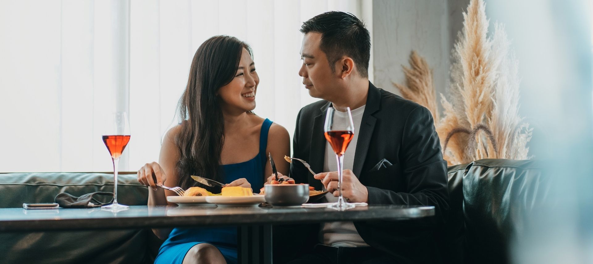 a couple is dining out with glasses of wine on the table