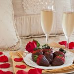 Chocolate-dipped strawberries with rose petals and sparkling cider