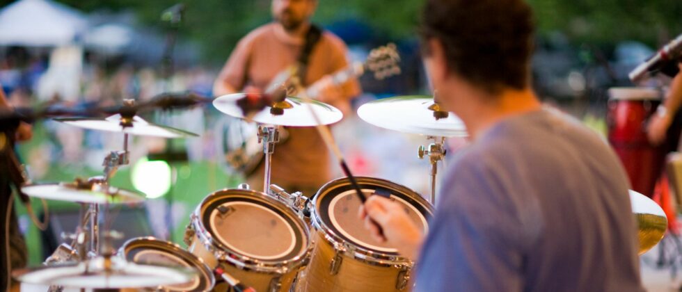 person playing drums at an outdoor venue