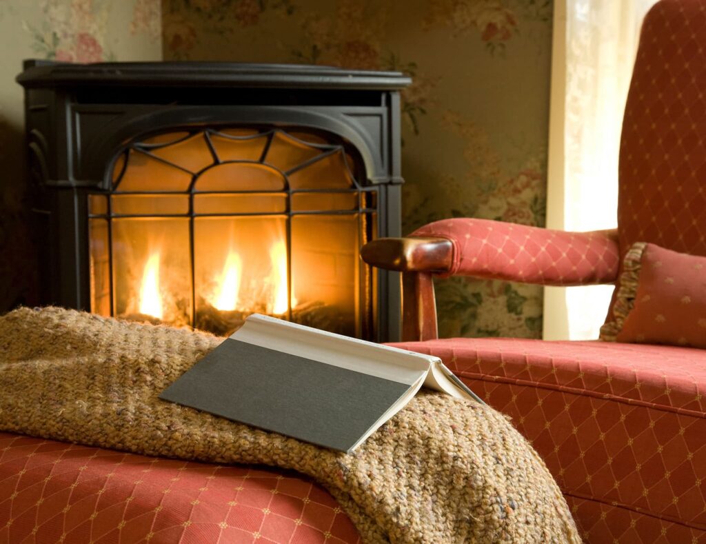 book in front of the fireplace in a cozy scene, making us one of the best Rockland, Maine hotels